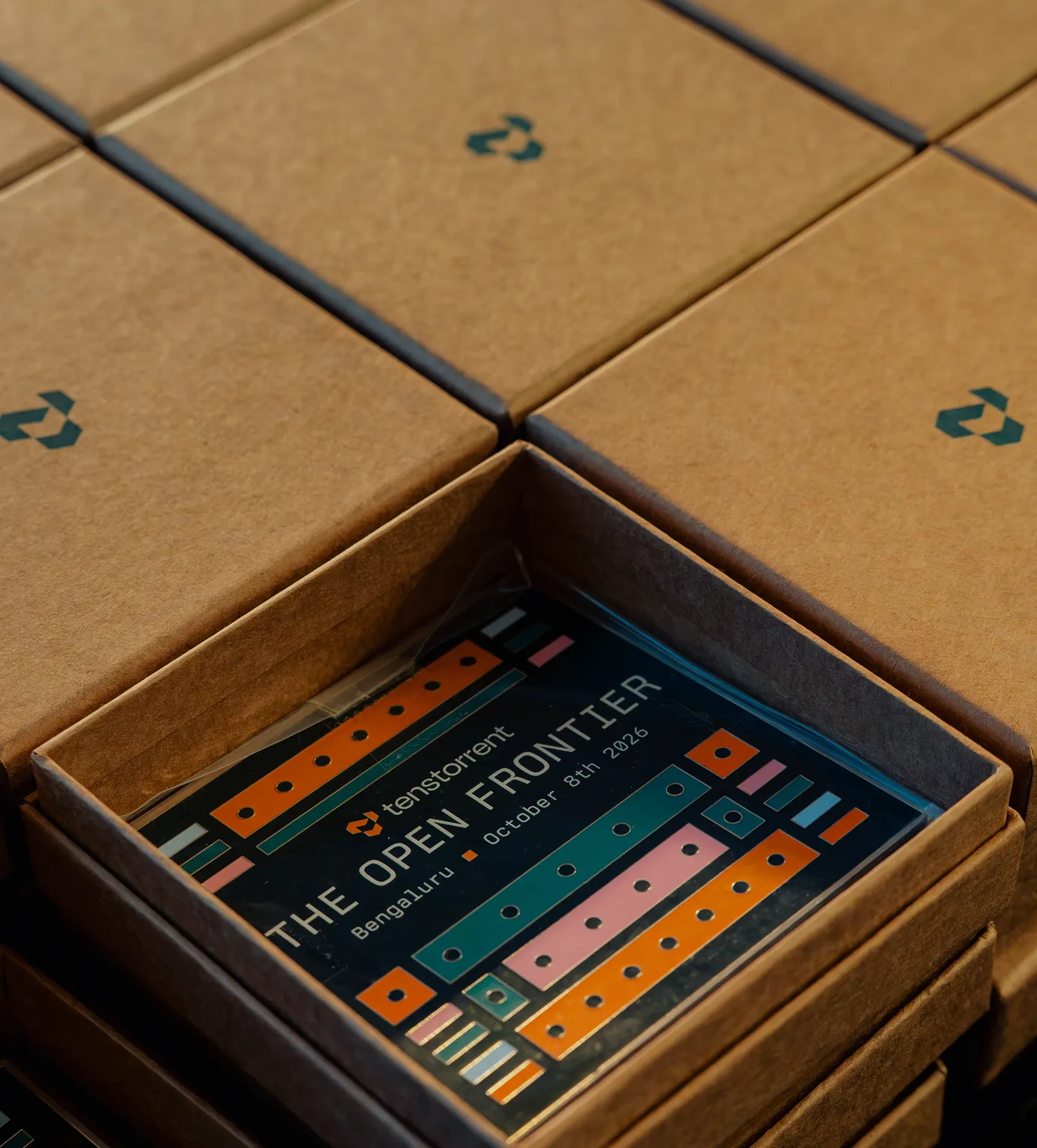 Branded attendee kit boxes with The Open Frontier card from Tenstorrent