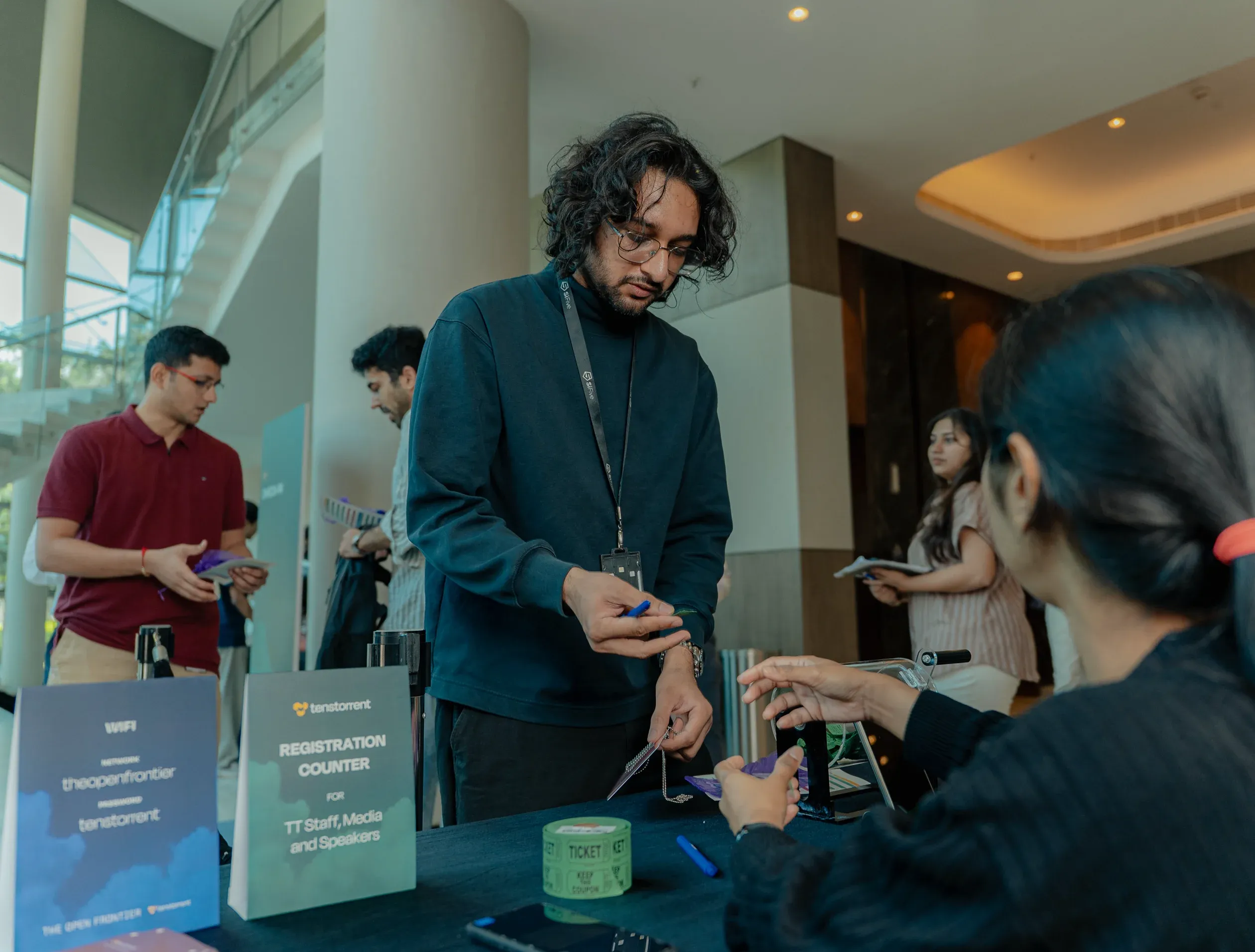 Attendees checking in at The Open Frontier registration counter with branded signage